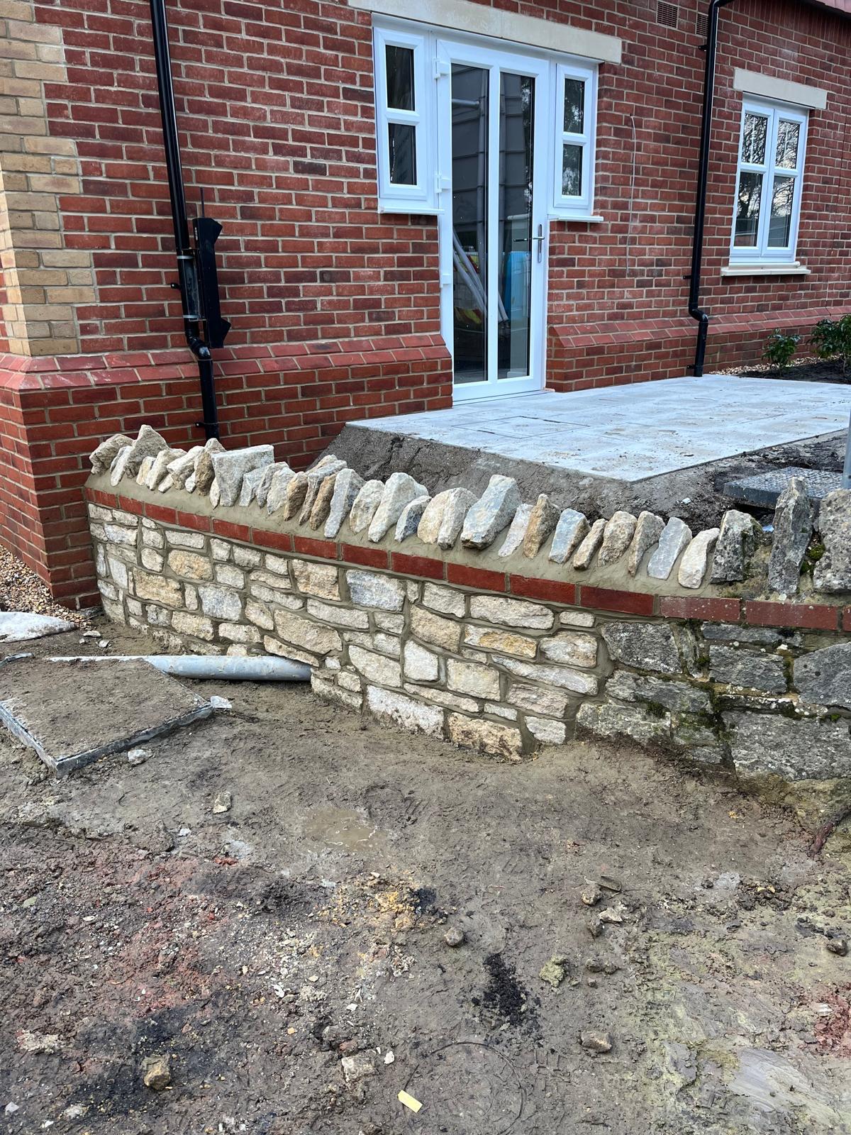 Liphook cobble wall with stone-capped brick piers