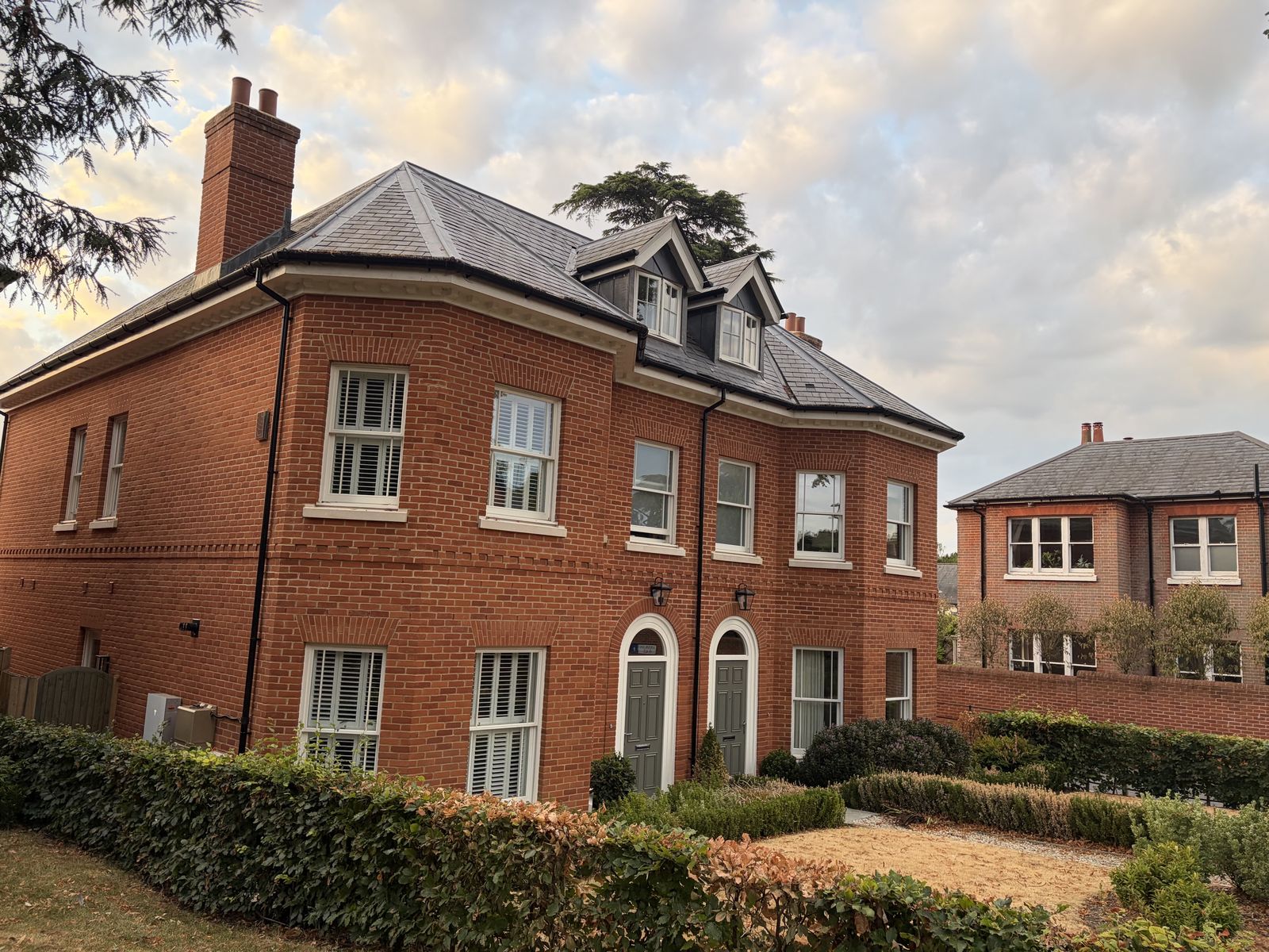 Red-brick homes with dormers and arched doorways at the St Cross Road development