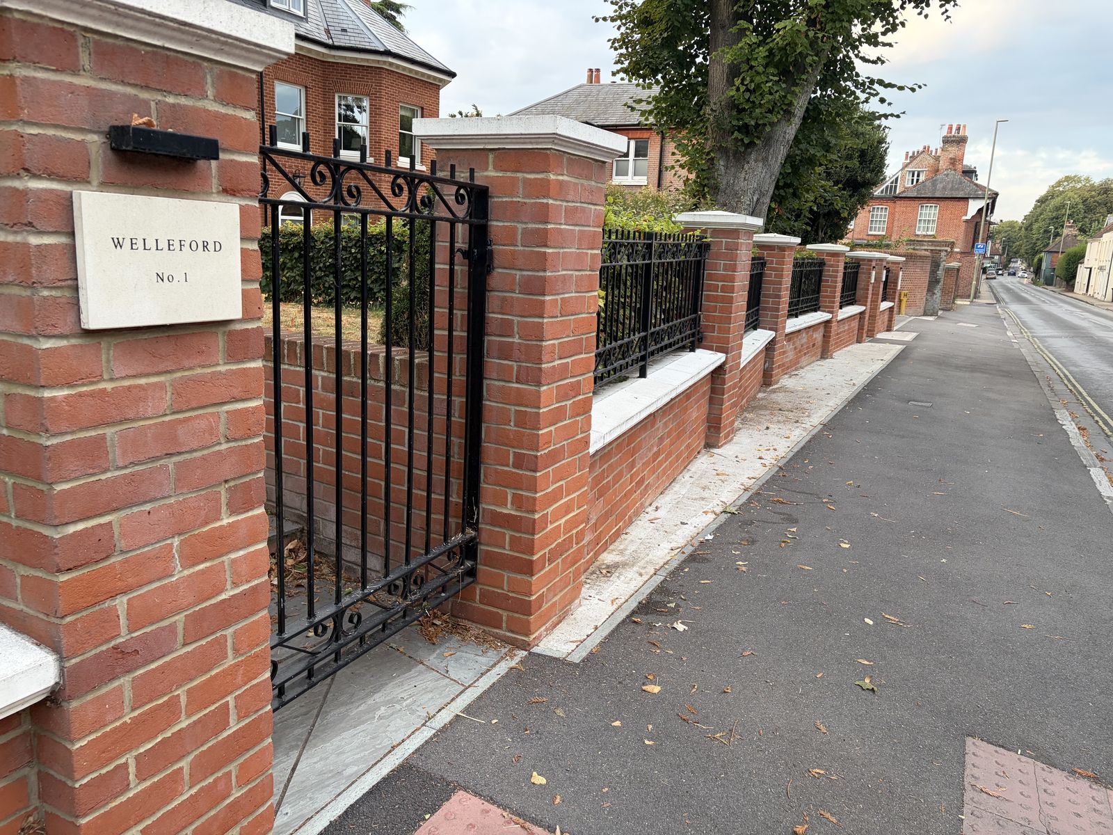 Brick entrance piers and iron railings at the St Cross Road development in Winchester