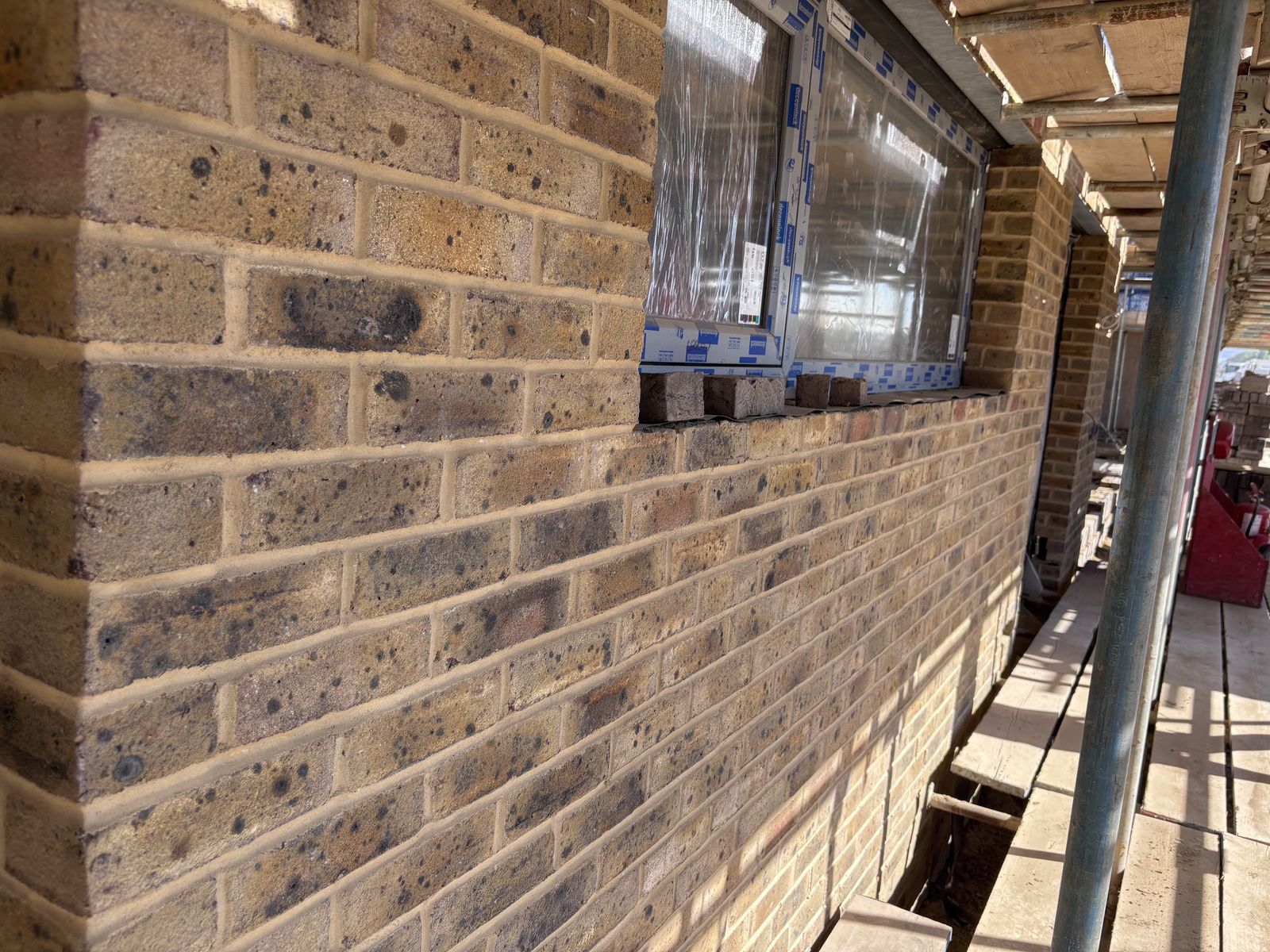 Completed brick elevation under scaffolding at Tipner East